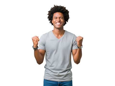 Excited young man with curly hair celebrating success with raised fists up