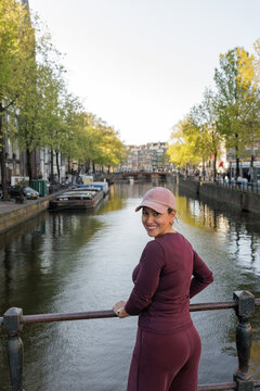 Woman looking back beside a canal in Amsterdam, Netherlands.