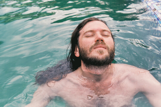 Man relaxing in a pool during a sunny day