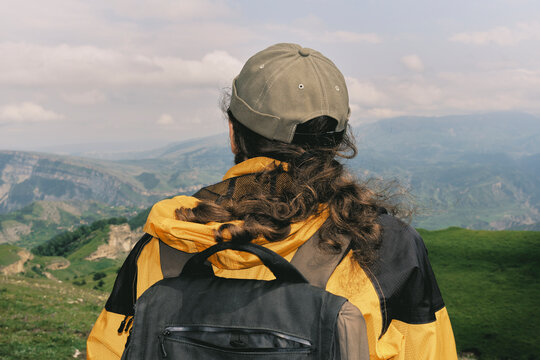 Person looks out at mountains from a high point on a cloudy day