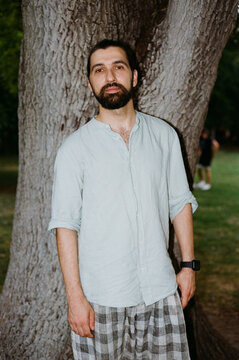 Man Standing by a Tree in a Public Park During the Day
