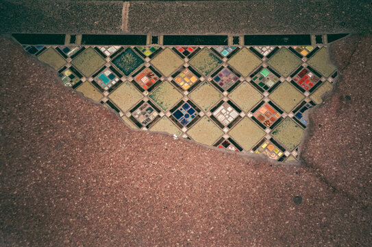 Colorful mosaic tiles revealed beneath worn ground surface