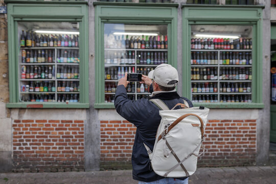 Man Tourist Taking Photo of Beer Window Display in Ghent Belgium