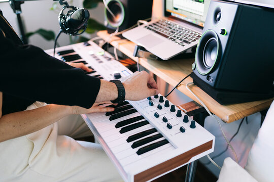 Couple creating music in home studio with synthesizer