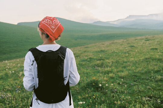Hiker explores green hills during early morning in nature
