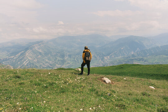 Person stands on mountain looking at valley