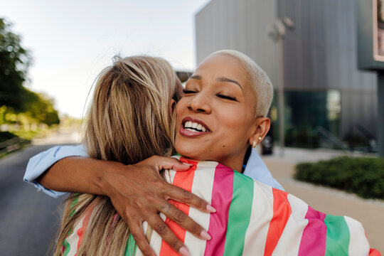 Happy woman embracing friend showing affection and joy