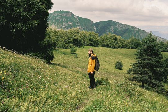 Hiking in a green field with mountains in the background
