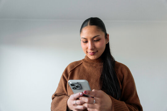 Young woman looking down at mobile