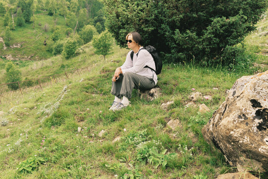 Woman sitting on grass in a green area during daytime
