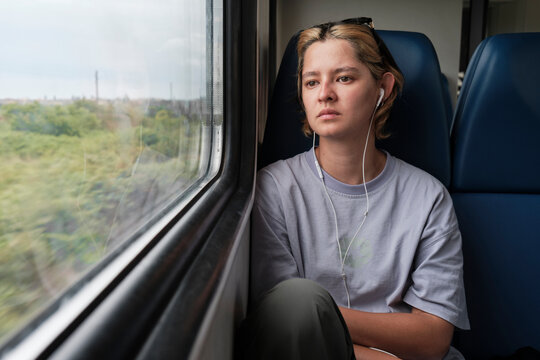 Woman looks out window while traveling on a train