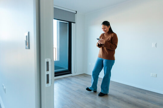 Woman texting in empty flat