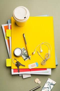 Back to school concept with scattered daily objects on yellow notebook