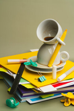 Stack of colorful school supplies and coffee cups in a lo-fi setup