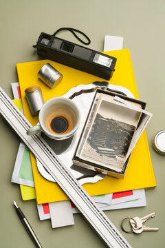 Vintage film rolls, photos, camera, cup of coffee on  yellow notebook