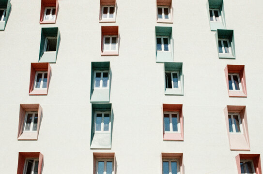 Colourful protruding windows on white building facade