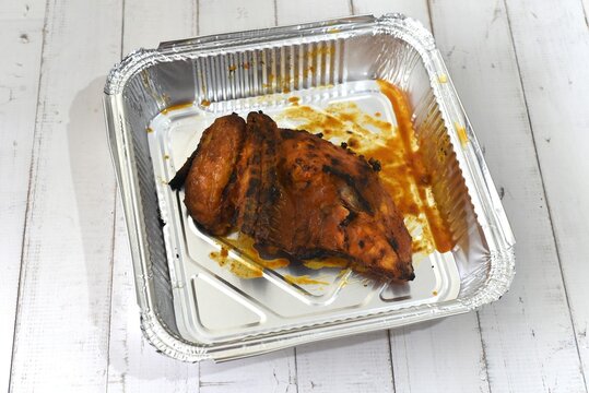 Image of quarter peri peri chicken in aluminium tray.