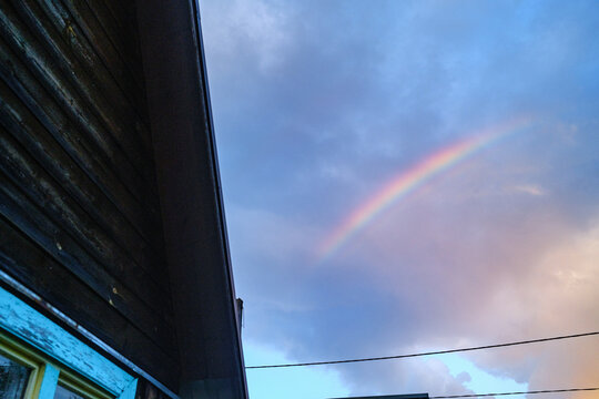Rainbown Appears in Sky Beside Wooden House