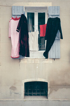 Clothes drying outside a blue shuttered window