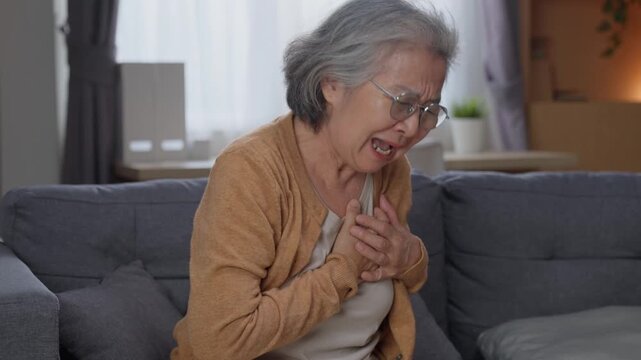 Elderly woman touching chest experiencing sudden heart palpitation and anxiety