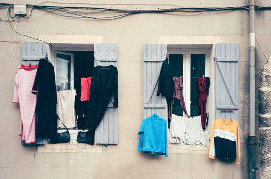 Colourful clothes hanging between shuttered windows