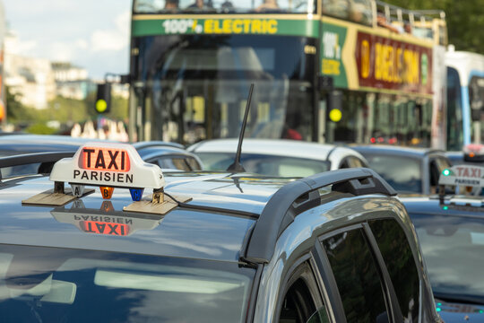 Parisian taxi in traffic with electric bus and urban transportation in central Paris, France