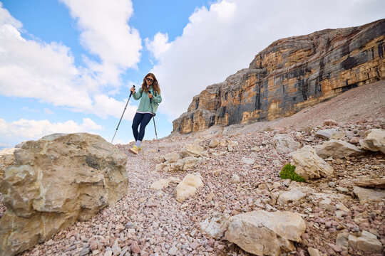 Woman hikes downhill in the Dolomites.