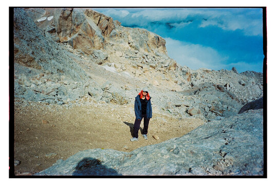 Person hiking on rocky terrain in mountainous area