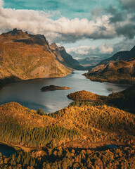 Vertical aerial view of a majestic fjord surrounded by golden autumn mountains in Norway with copy space in sky © Quality by Simon