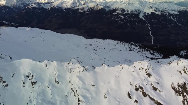 Cinematic Aerial Drone View Over Snow-Covered Mountain Ridges in Austrian Alps Winter Landscape