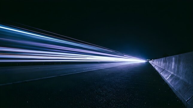 Long exposure light trails streaking across a dark modern highway at night