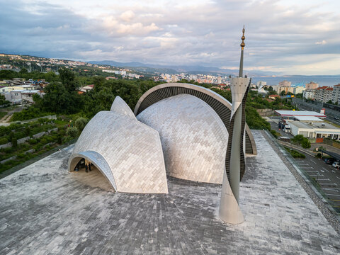 Rijeka, Croatia - 05 18 2025: Angled drone photo from down showing the Islamic Center of Rijeka (Islamski centar u Rijeci) with its minaret, parking lot, highway, buildings, Adriatic Sea