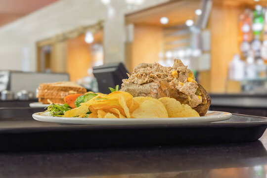 Tuna and sweetcorn jacket potato with crisps and salad on cafe c
