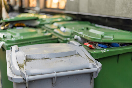 Wheelie bins outside city centre shops, overflowing waste