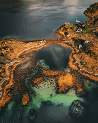 Vertical aerial top down view of turquoise clear water lagoon and autumn coast in northern Norway with copy space in ocean © Quality by Simon