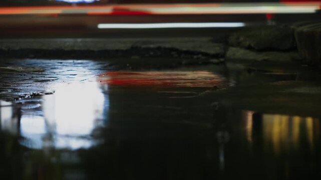 Slow shutter traffic reflections in a rain puddle in Bangkok