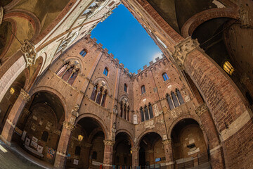 Obraz premium Siena, Tuscany, Italy – May 23, 2026: The inner courtyard of the Palazzo Pubblico (the city hall), with medieval Gothic architecture. Build in 1297 to house the government of the republic.