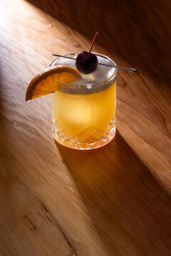 Beautiful Whiskey sour served on the rocks garnished with an orange slice and a dark cherry