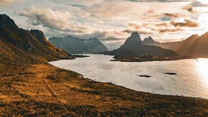 Panoramic aerial view of a dramatic mountain peak and fjord under golden sunlight in northern Norway © Quality by Simon