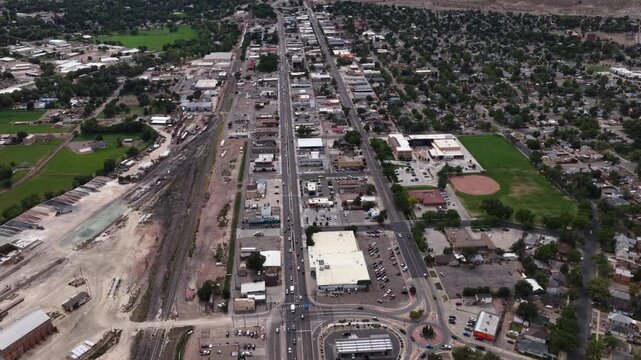 Aerial of small American town center in Canon City Colorado old mining town featuring a central commercial corridor running parallel to active railroad tracks