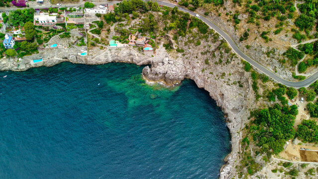 Drone view of curving coastal road on Amalfi Coast with sea views