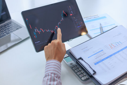 Businessman monitoring on screen of stock market and analyzing data of investment portfolio trends.
