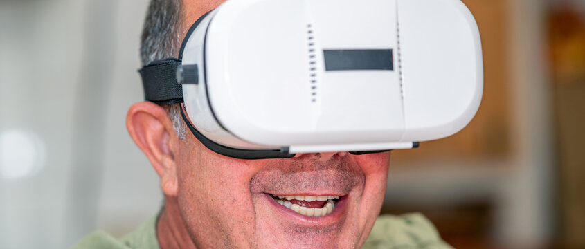 Happy face of a man using 3D VR visor. Virtual reality experience