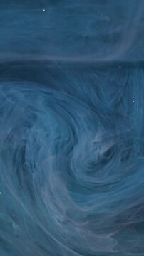 Vertical video. Ink mist. Swirl blue vapor. Defocused color glitter cloud splash sparkling liquid drop spreading on abstract dark black bokeh background.