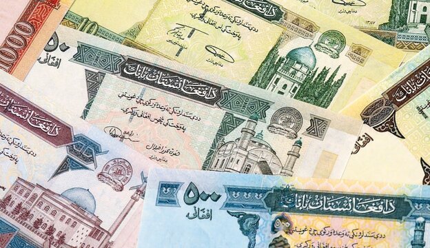 Afghan afghani money bills in pile on table. Afghanistan AFN currency cash close up