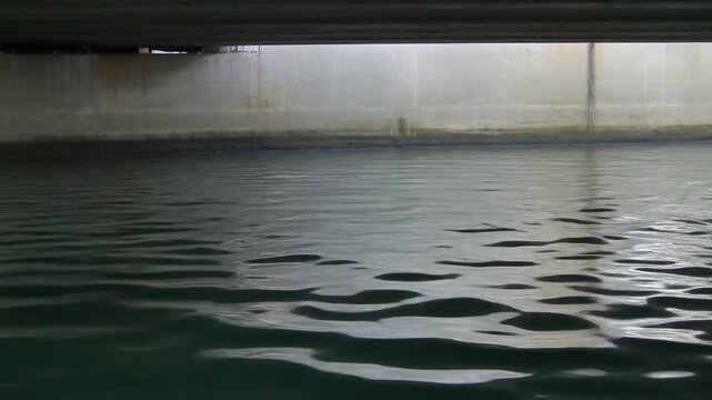 Water reflections rippling under a bridge