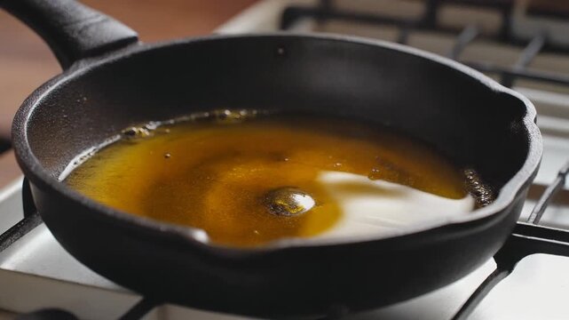 Oil shimmering in a hot cast iron pan