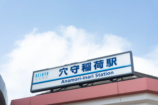 青空に映える京急線の駅名看板が印象的な「穴守稲荷駅」のクリーンな外観スナップ