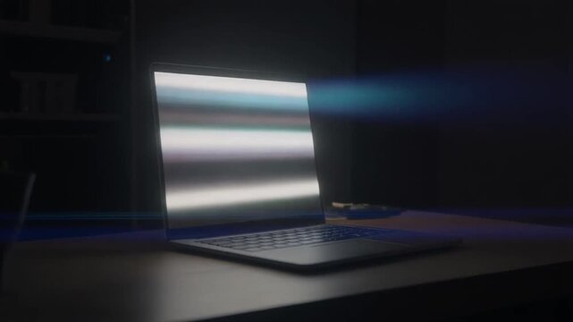 Laptop glowing in a dark room