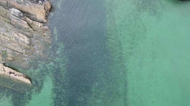 High Angle Footage of Beach and Ocean at Looe Town of England During Hot Sunny Day. Looe is a coastal town and civil parish in southeast Cornwall, England, United Kingdom.